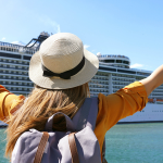 Young girl standing excited in front of a cruise ship