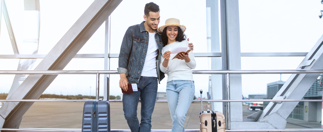 Smiling couple at airport with luggages