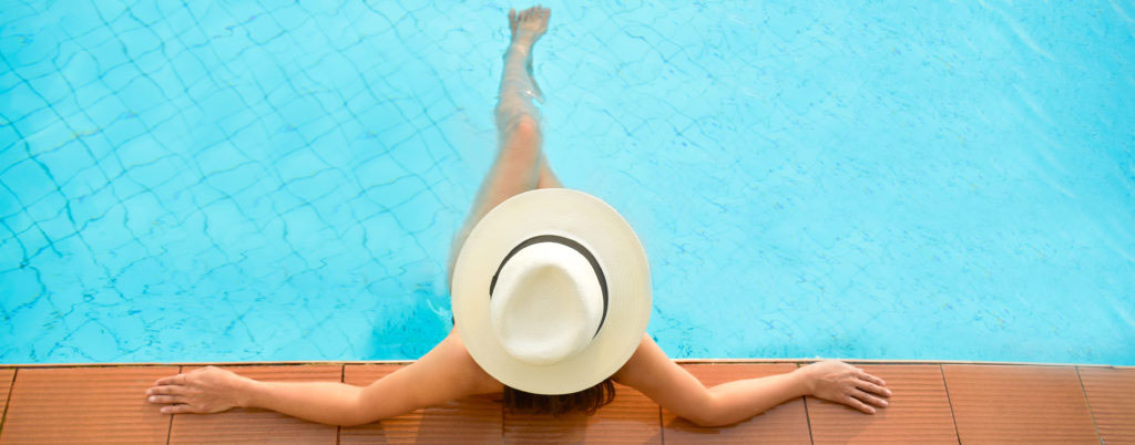 Asia woman lifestyle relaxing near luxury swimming pool sunbath summer day at the beach resort in the hotel. Concept Summer