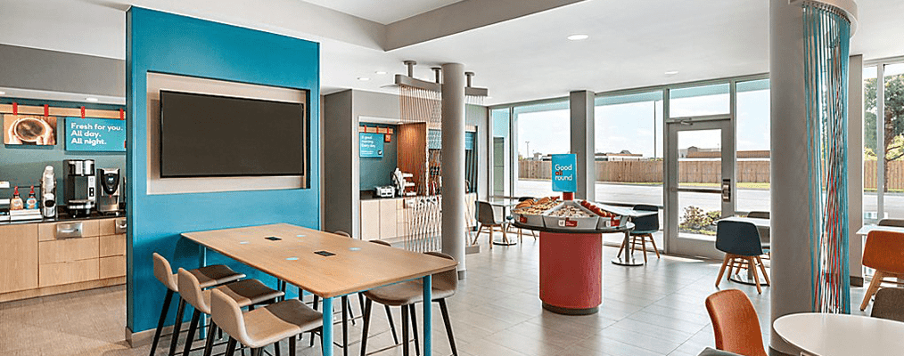 Avid Hotel Orlando Airport Dining area, featuring modern seating, a food station, and coffee machines