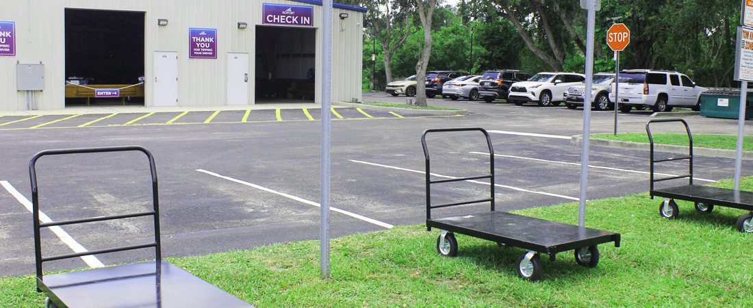 Luggage unloading area at Go Port's free cruise parking, with signs for unloading and loading spaces with luggage carts