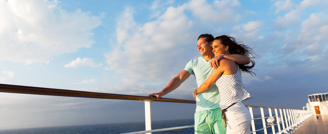 Couple holding each other and looking into the distant on the cruise, standing by the balcony