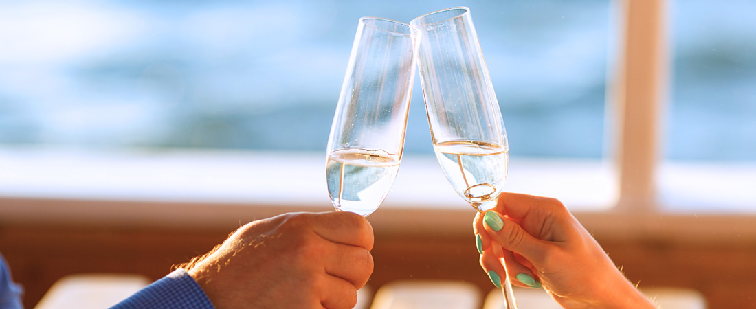 couple hands cheering two flute glasses of champagne