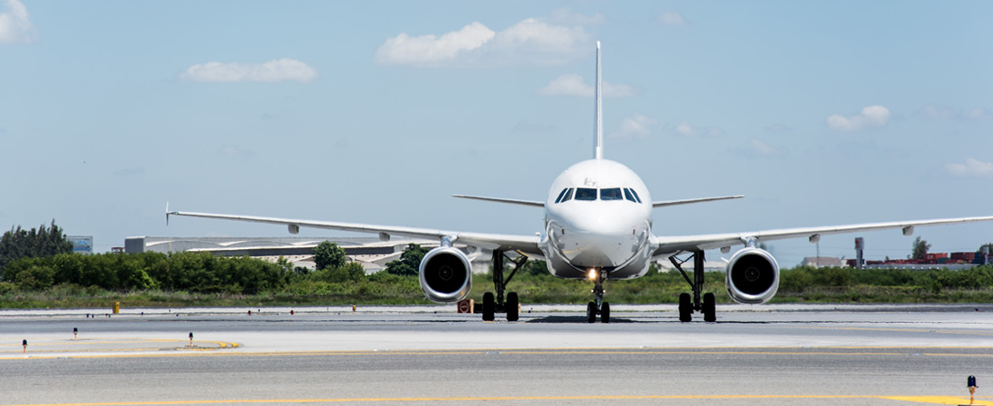 White aircraft waiting to take flight on airport walkway