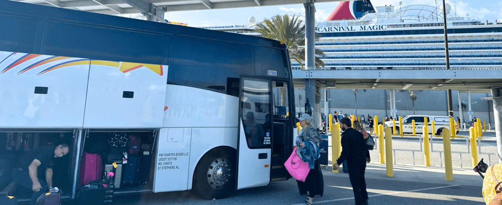 Guests debarking Port Canaveral cruise from Carnival terminal getting ready to board a shuttle bus