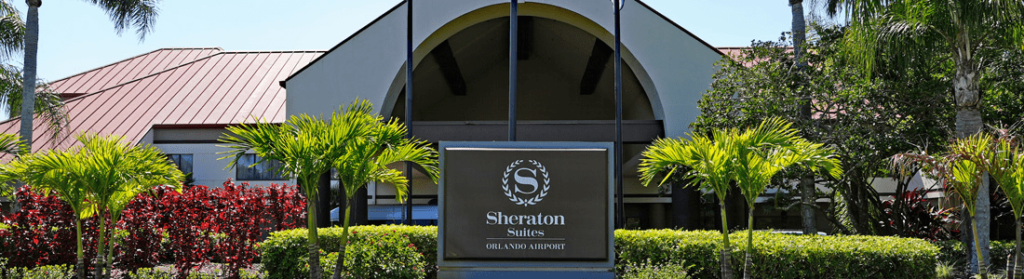 Exterior view of the front of Sheraton Suites Orlando Airport hotel with Port Canaveral cruise shuttle