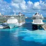 3 cruise ships on the water docked at port Nassau Bahamas with blue skies in the background.