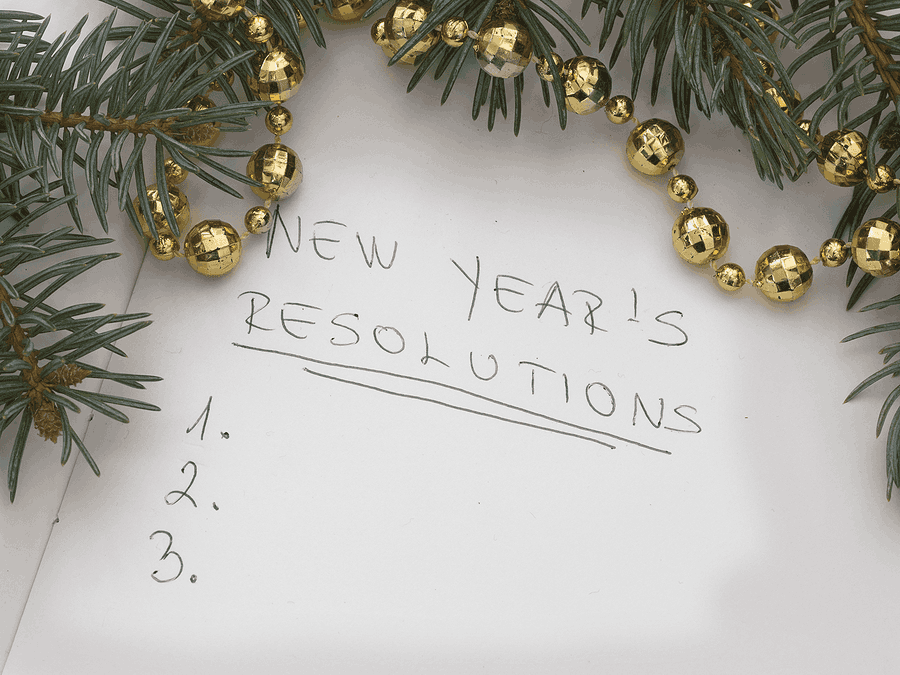 Written on paper, the words "New Years Resolutions", with a list of numbers.