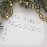 Written on paper, the words "New Years Resolutions", with a list of numbers.