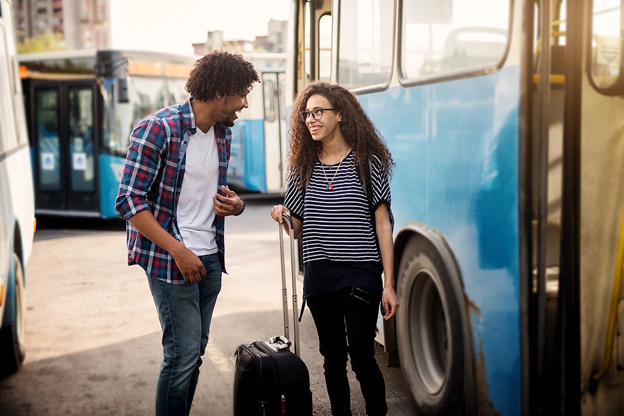 young couple boarding bus for vacation