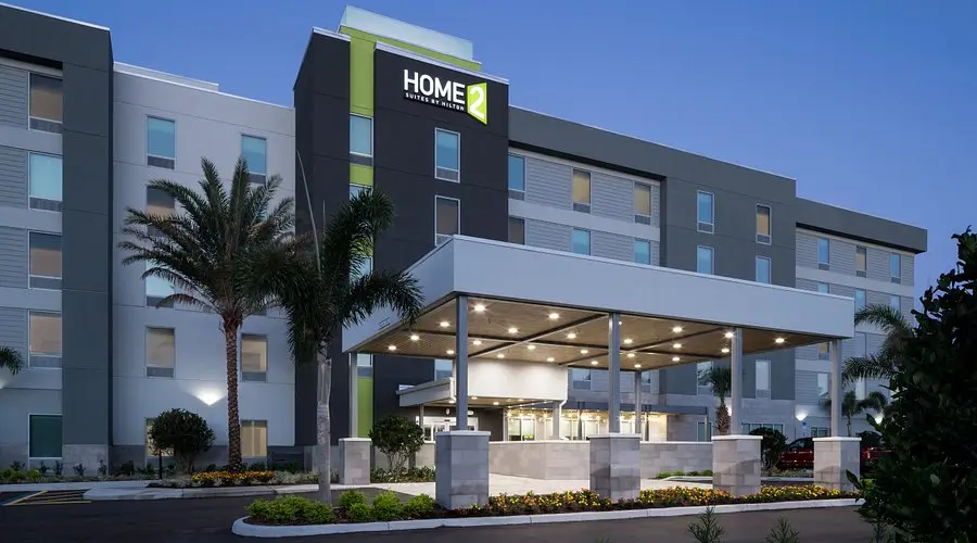 Exterior at night of home2 suites by Hilton. 