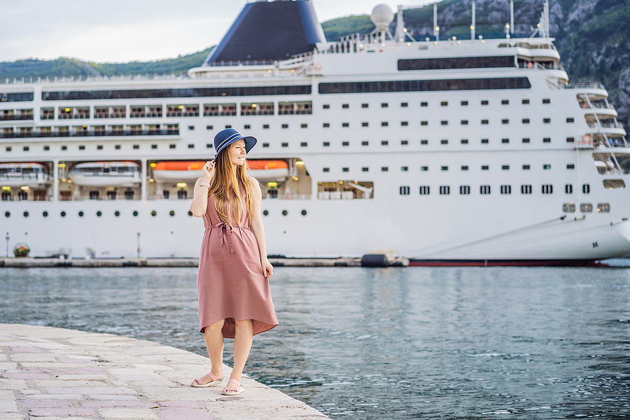 Young woman enjoying an empty port next to her cruise ship. 