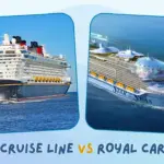 Disney Cruise Line ship sailing the ocean next to Royal Caribbean ship, with a blue sky behind.