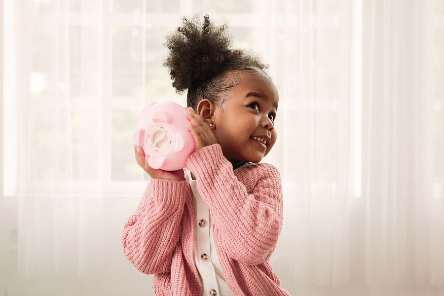Little girl holding up a piggy bank 