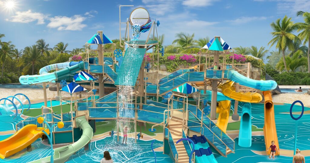 Colorful tropical splash zone at Great Stirrup Cay featuring multiple water slides, climbing platforms, spray features, and a giant tipping bucket surrounded by palm trees.