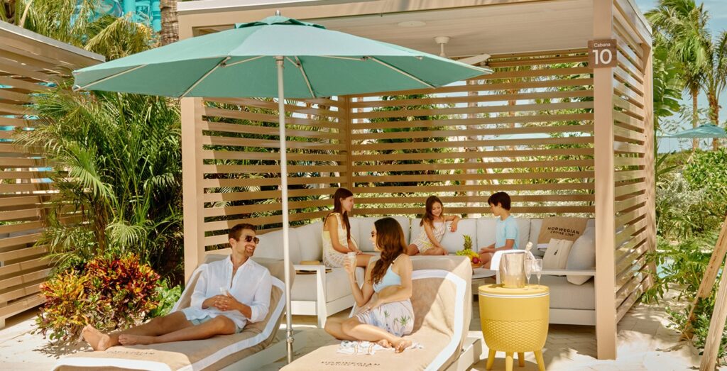 A family relaxing in a cabana, palm trees behind them.